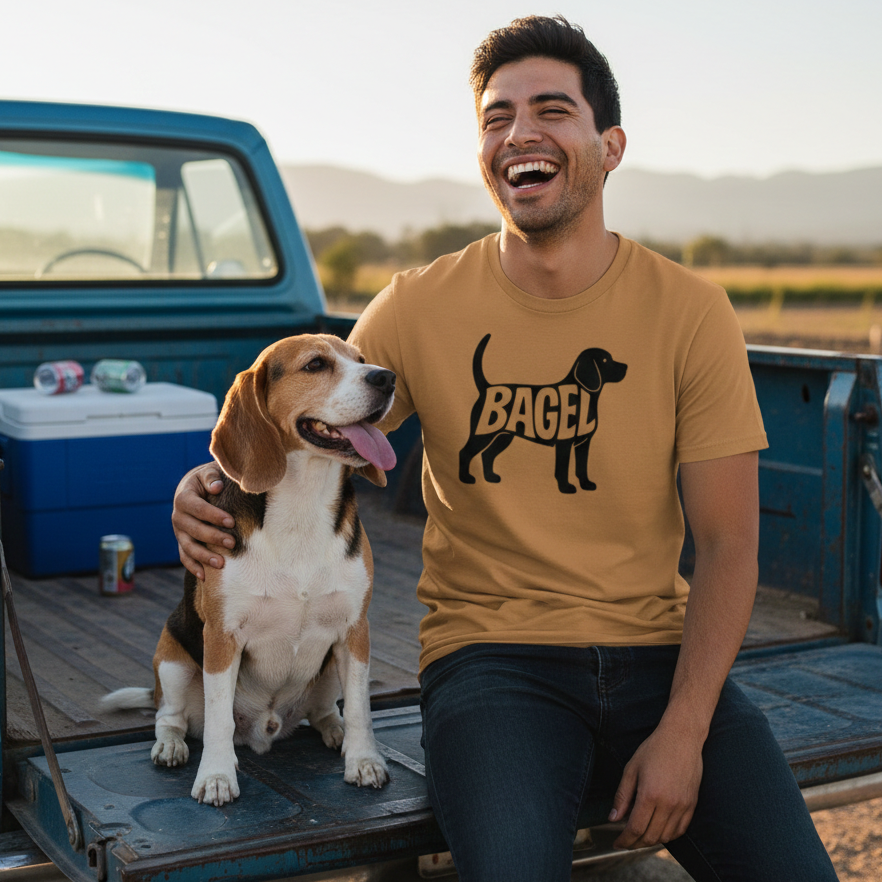 Man sitting in the back of a pickup truck with a dog, wearing a shirt with a beagle design.
